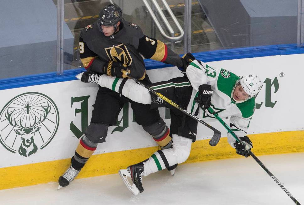 Dallas Stars' Mattias Janmark (13) is checked by Vegas Golden Knights' Brayden McNabb (3) durin ...