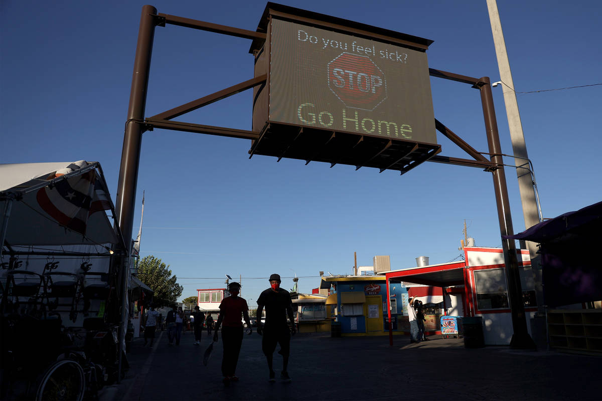 A digital sign reminds people to go home when sick at Broadacres Marketplace in North Las Vegas ...