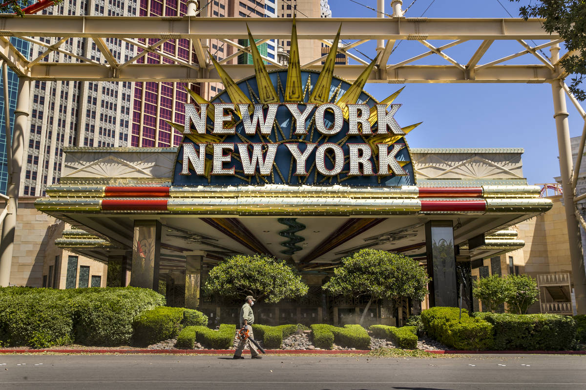 A landscaper blows clippings after trimming the bushes in front of New York-New York on the Las ...