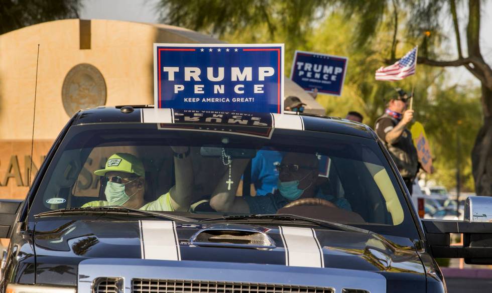 A driver and passenger show their support for protestors rallying at the Grant Sawyer building ...