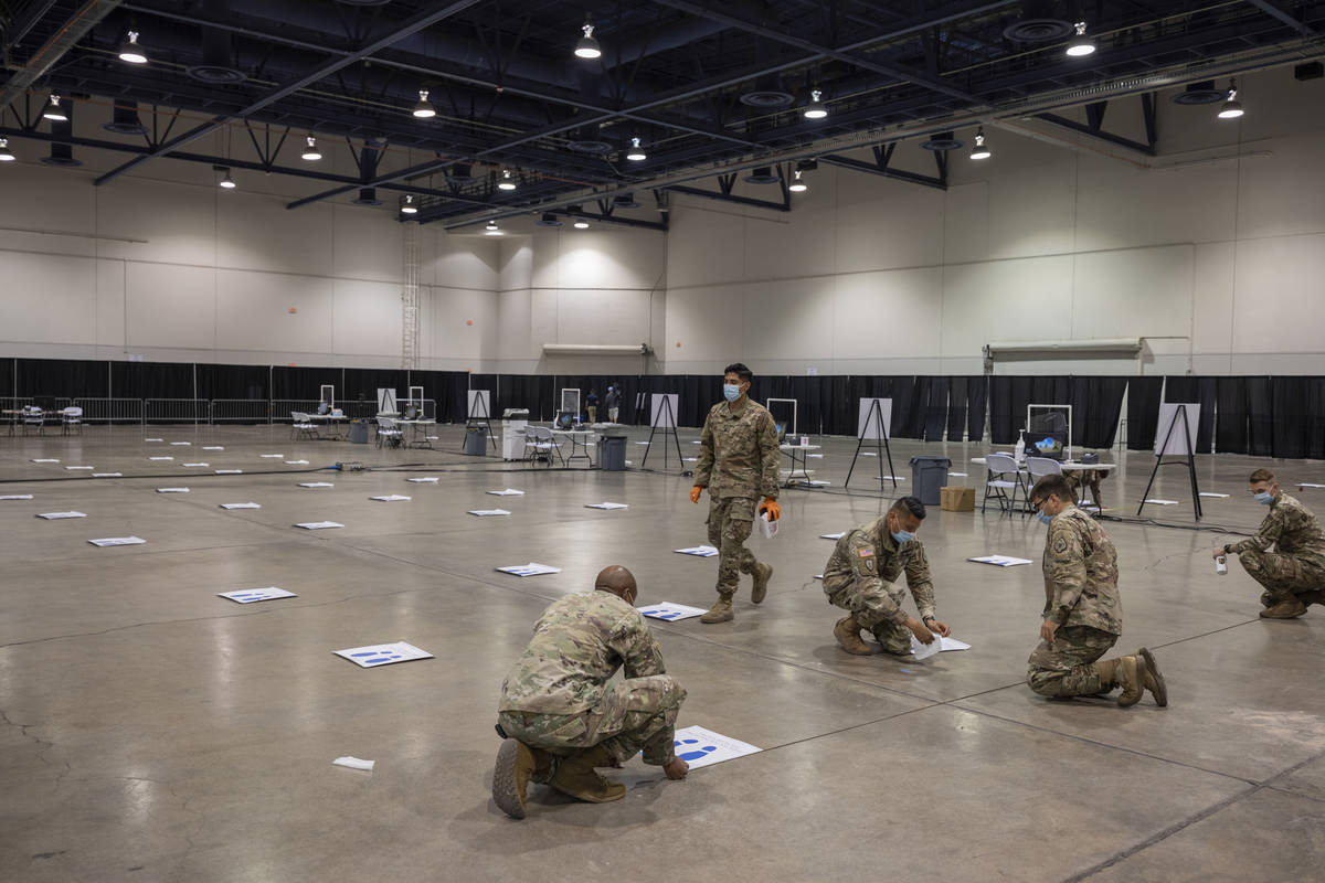 The National Guard puts down six feet markers in preparation of a new COVID-19 testing site ins ...