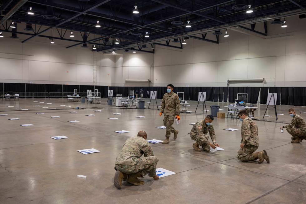 The National Guard puts down six feet markers in preparation of a new COVID-19 testing site ins ...