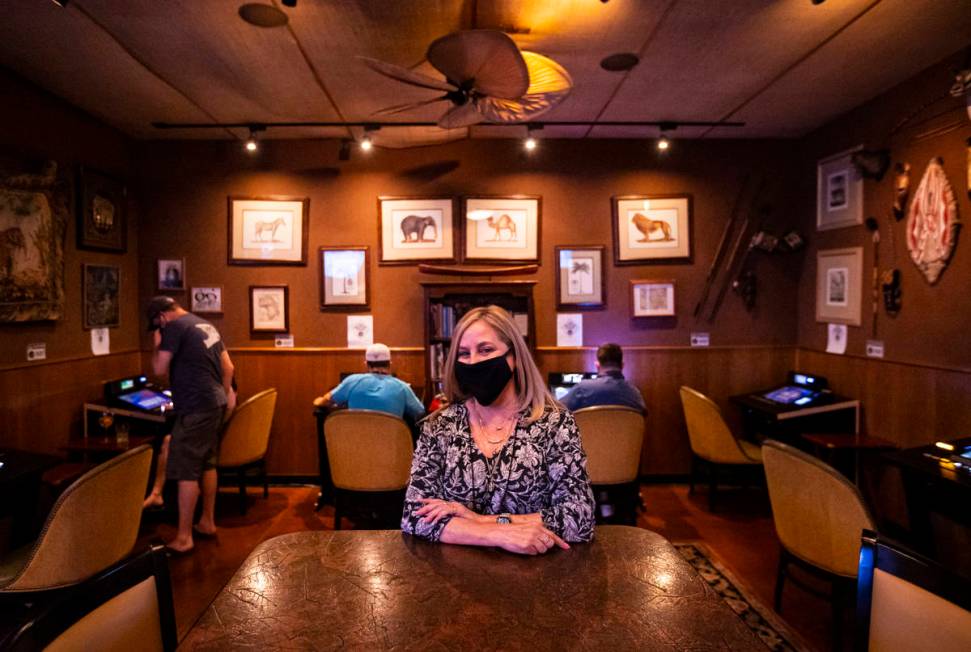 Donna Rocker, owner of Black Mountain Grill, poses by a gaming lounge area at the restaurant an ...