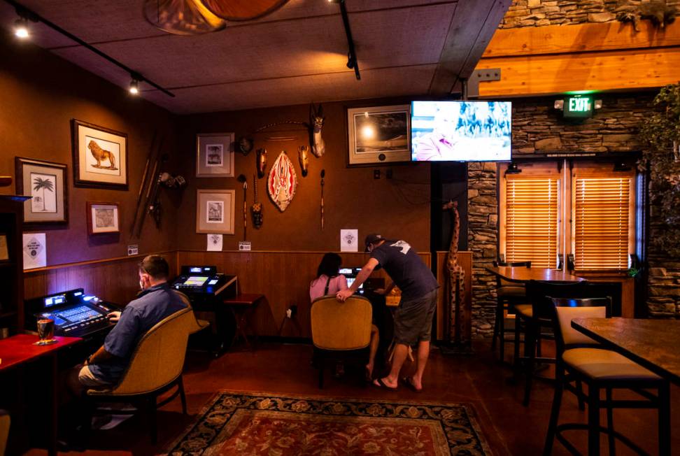 Kelly and Pete, center, who declined to give their last names, play on gaming machines that wer ...