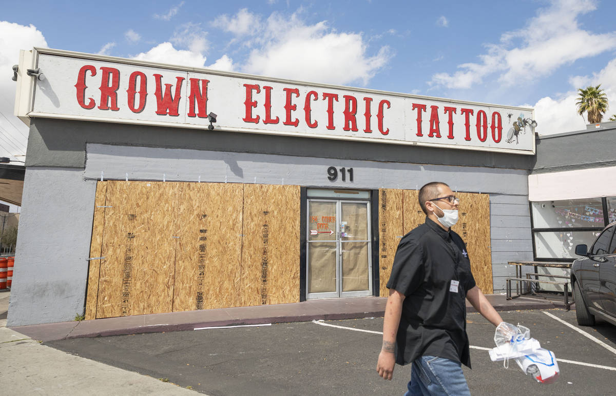 Surgio Aguirre of North Las Vegas walks by the recently boarded Crown Electric Tattoo Co. locat ...