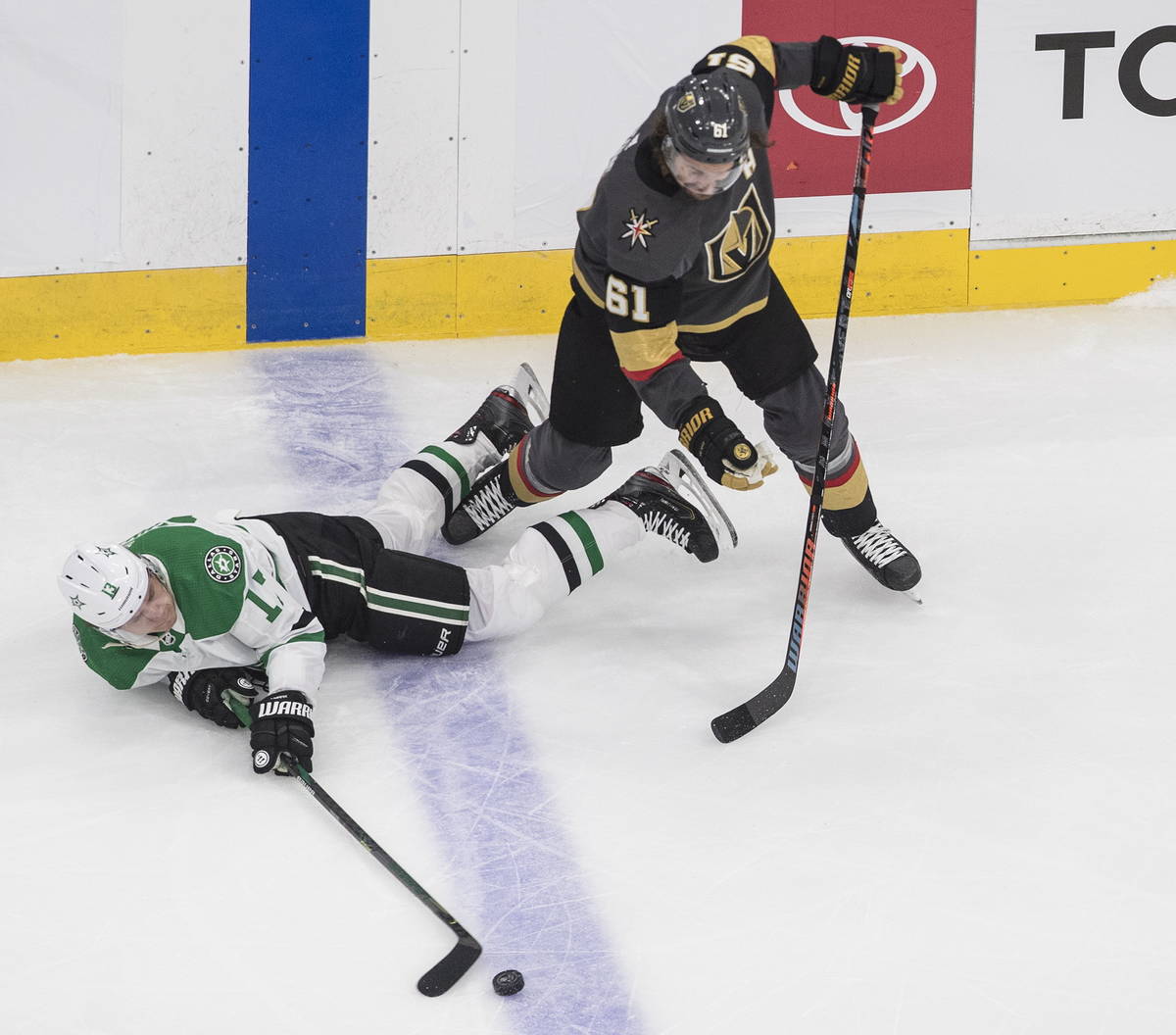 Dallas Stars' Mattias Janmark (13) is tripped up by Vegas Golden Knights' Mark Stone (61) durin ...