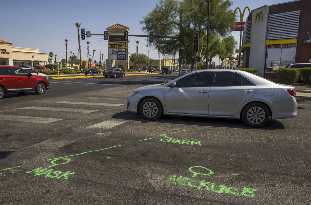 Accident markings identify evidence near where a small memorial has begun and tree limbs are st ...