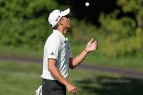 Collin Morikawa tosses a ball after putting on the second green during a practice round for the ...