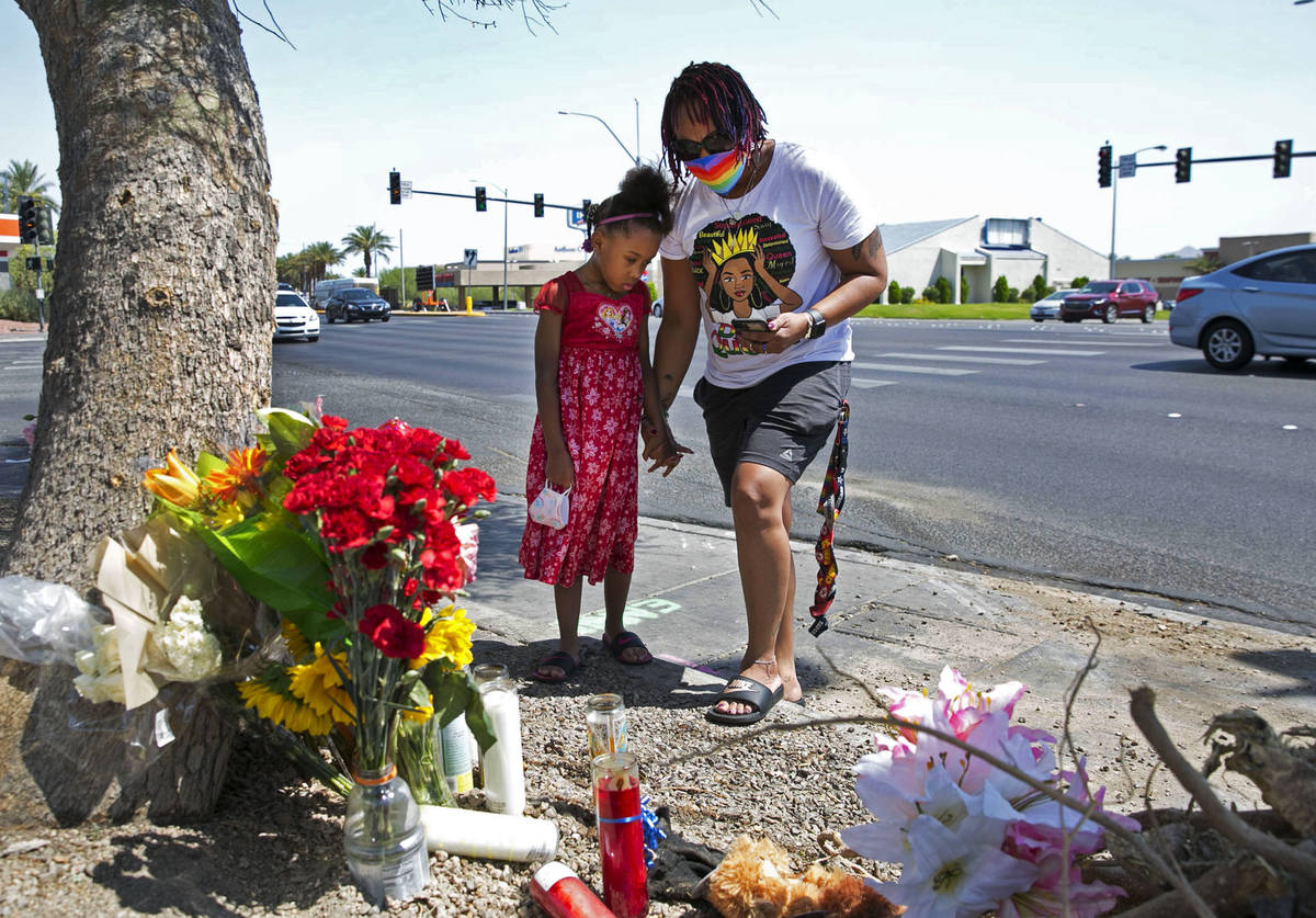 Tiffany Joseph and her daughter Jordan, 6, visit a makeshift roadside memorial on Wednesday, Au ...