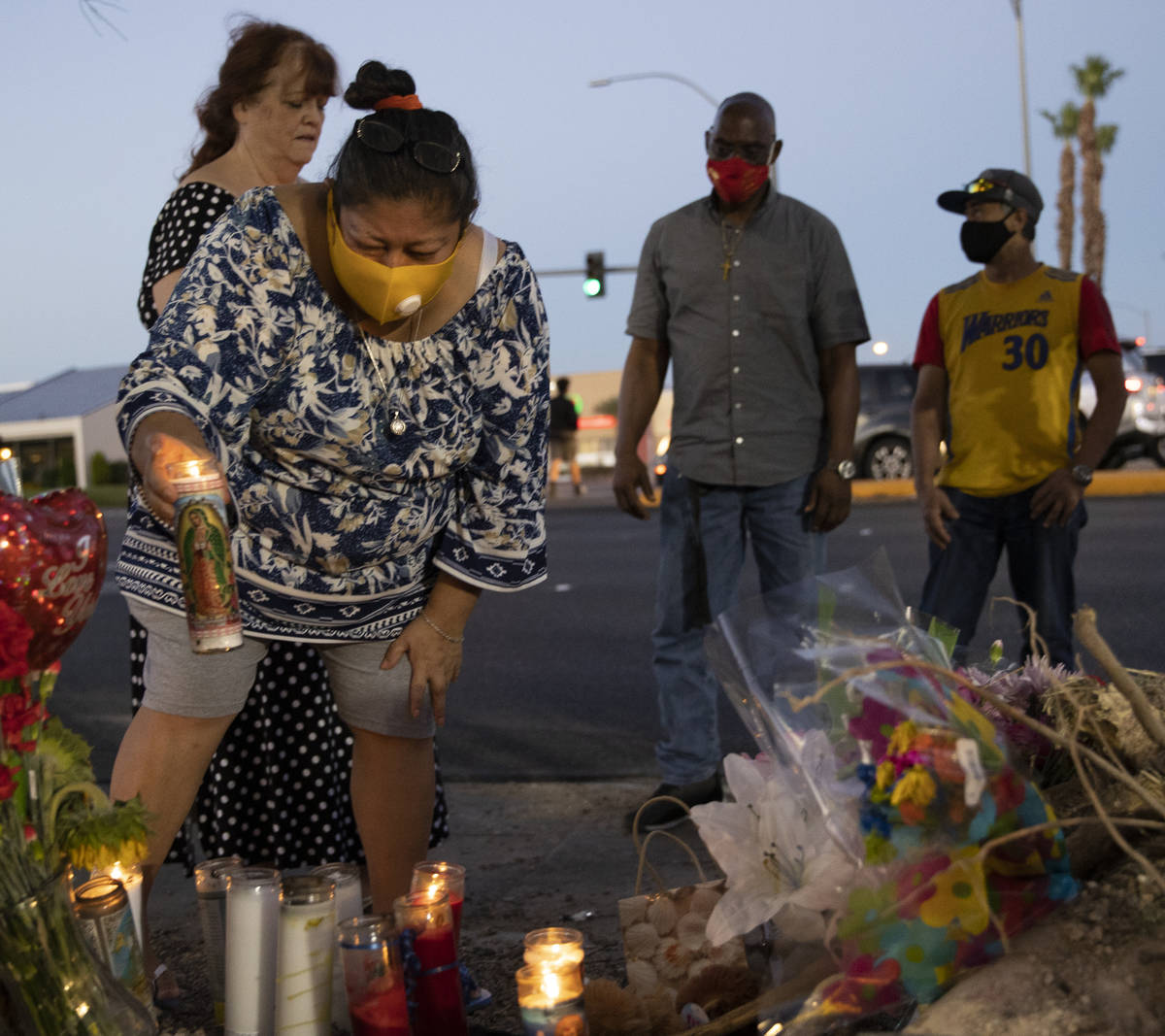 Minerva Rodriguez, left, places a candle with a group of others during a vigil for Nelly Amaya- ...