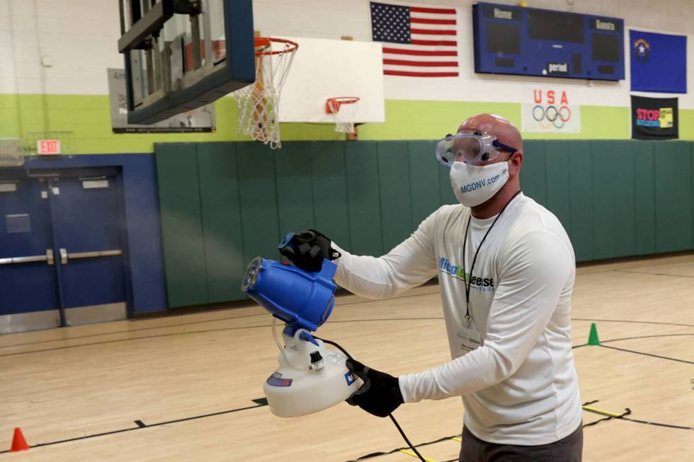 Technician Marc Kmetz of MicroGerm Defense Nevada uses an electrostatic sprayer at James Boys & ...