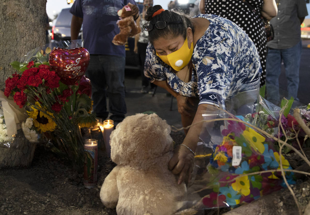 Minerva Rodriguez places a teddy bear with a group of candles during a vigil for Nelly Amaya-Ra ...