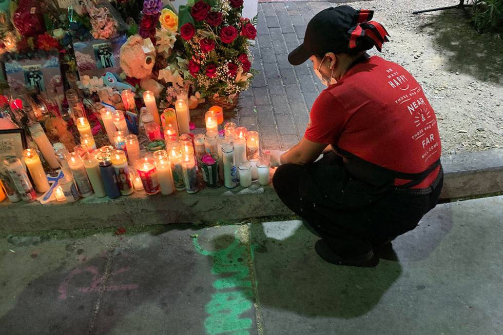 A Panda Express employee who gave only her first name, Jessica, lights a candle Friday night fo ...