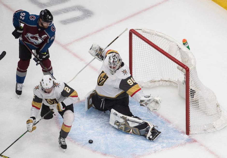 Colorado Avalanche's Gabriel Landeskog (92) and Vegas Golden Knights' Zach Whitecloud (2) look ...