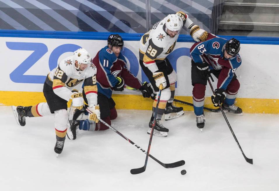 Colorado Avalanche's Matt Calvert (11) Matt Nieto (83) battle for the puck with Vegas Golden Kn ...