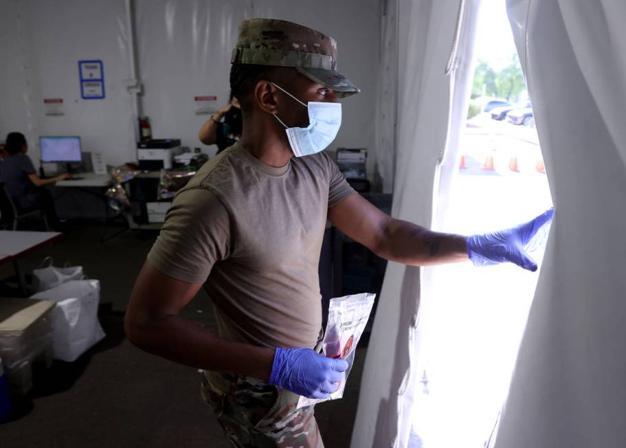 Nevada Air National Guard Airman 1st class Kevin Davis works on curbside testing for COVID-19 a ...