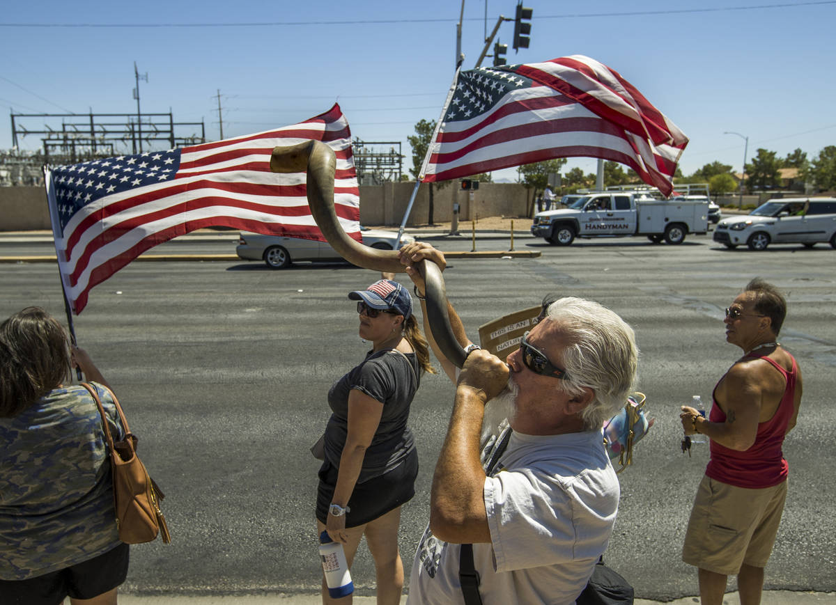 Brand Thornton, center, blows a shofar during a No Mask Nevada rally to oppose the face mask ma ...