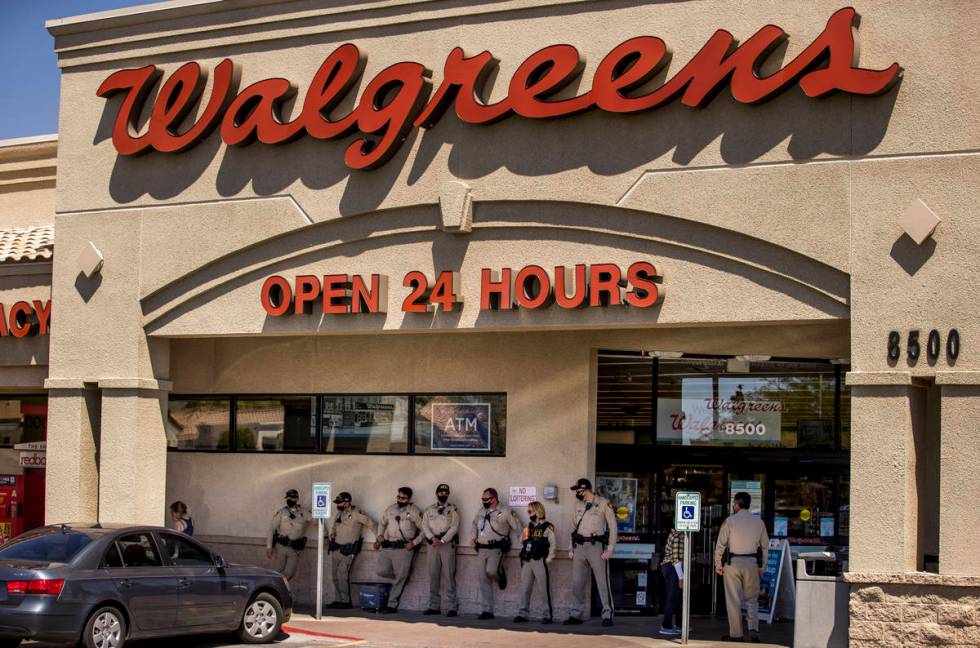 Las Vegas police officers keep cool at Walgreens while monitoring a No Mask Nevada rally to opp ...