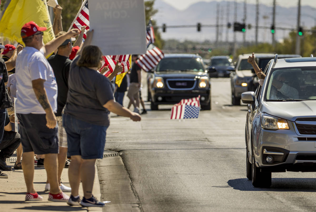 A driver gives the " thumbs up " sign to supporters during a No Mask Nevada rally to ...