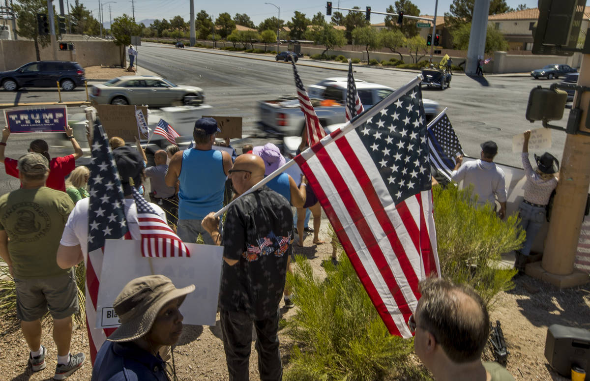 Supporters chat as traffic streams by during a No Mask Nevada rally to oppose the face mask man ...