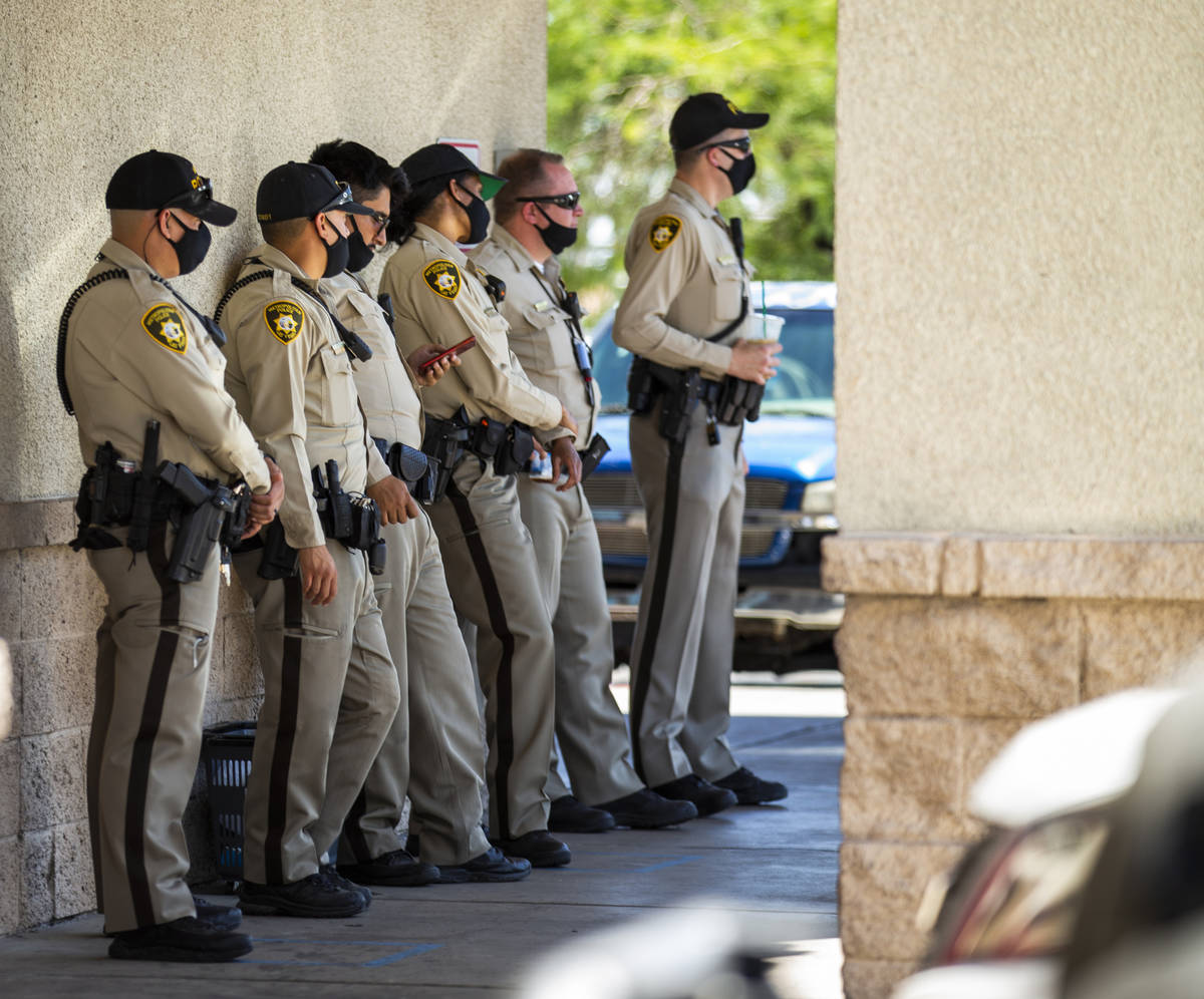 Las Vegas police officers keep cool at Walgreens while monitoring a No Mask Nevada rally to opp ...