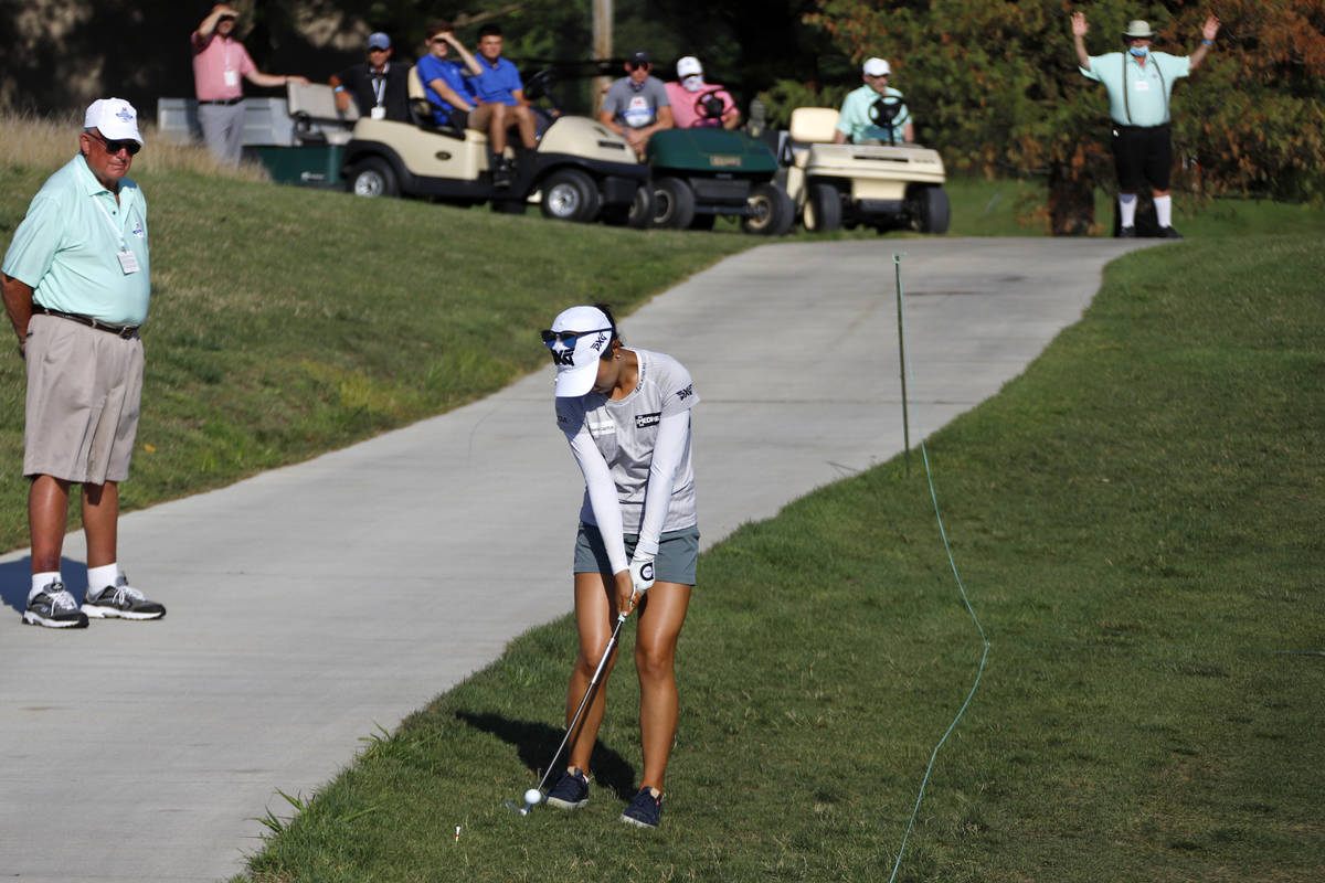 Lydia Ko of New Zealand hits her ball after taking a drop when her second shot on the 18th hole ...