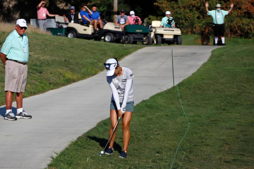 Lydia Ko of New Zealand hits her ball after taking a drop when her second shot on the 18th hole ...