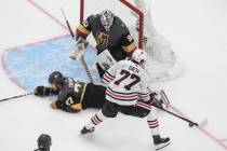 Chicago Blackhawks' Kirby Dach (77) is blocked by Vegas Golden Knights' Shea Theodore (27) as G ...