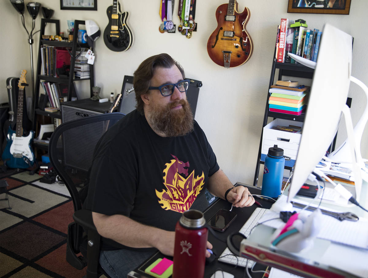 Paul Kleemann, a guitar director at Del Sol Academy, works on his computer at his home in Las V ...