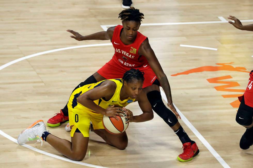 Indiana Fever guard Kelsey Mitchell (0) falls down in front of Las Vegas Aces forward Dearica H ...