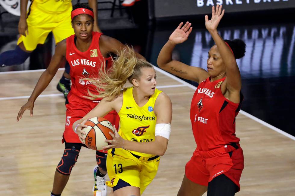 Indiana Fever forward Lauren Cox (13) drives into Las Vegas Aces center A'ja Wilson (22) and fo ...