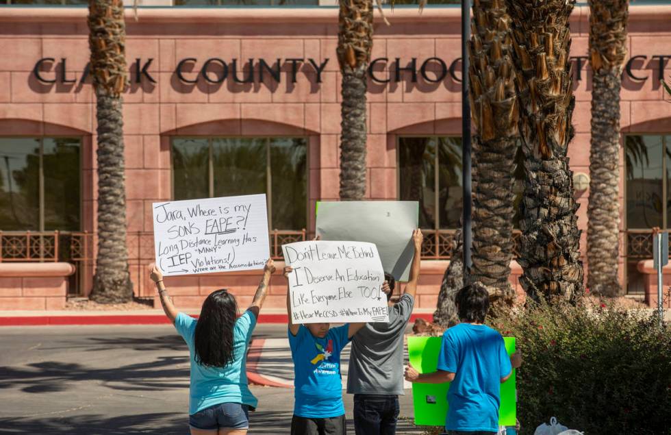 Parent and advocate Yesenia Gonzales, left, hold signs outside the Clark County School District ...