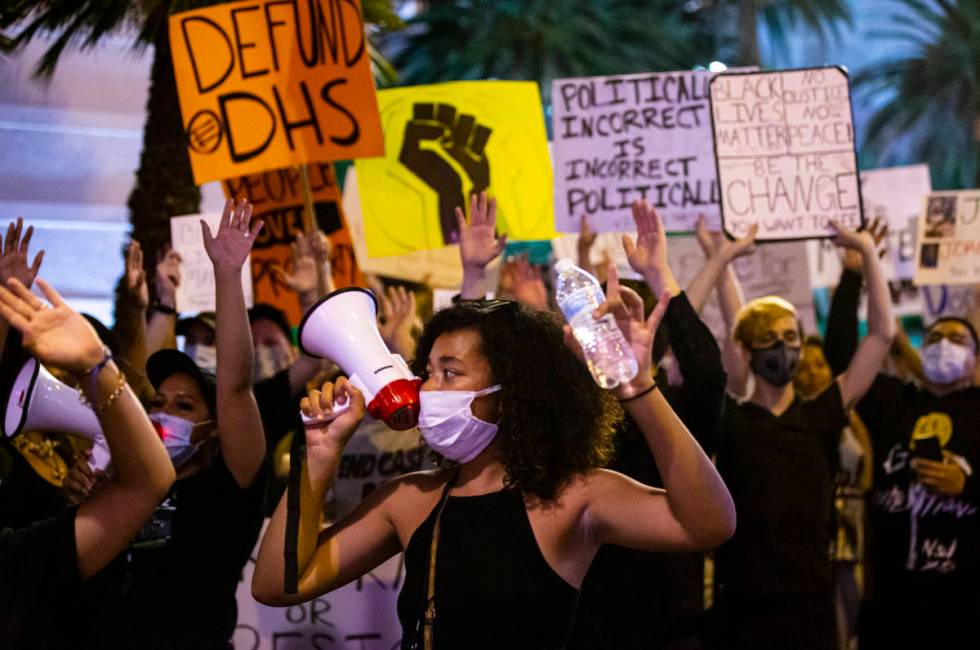 Rally organizer Nakitaa Fletcher holds up her hands as people march for Black Lives Matter and ...