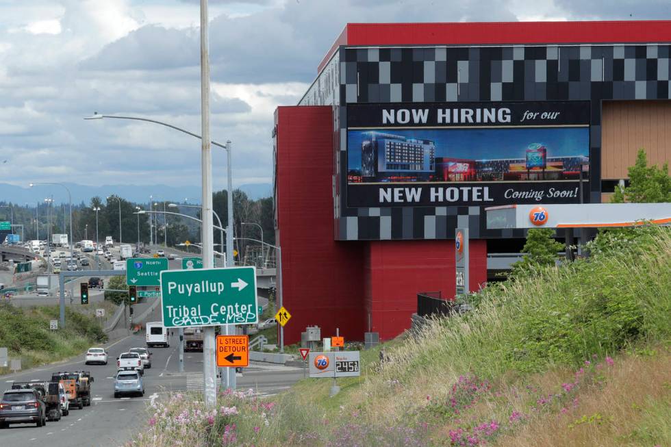 In this July 9, 2020, file photo, a large video display reads "Now hiring for our new hotel com ...