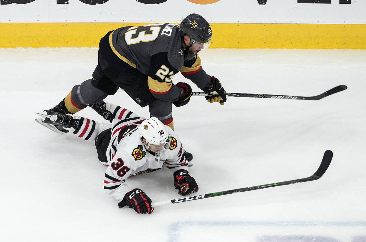 Vegas Golden Knights' Alec Martinez (23) checks Chicago Blackhawks' Matthew Highmore (36) durin ...