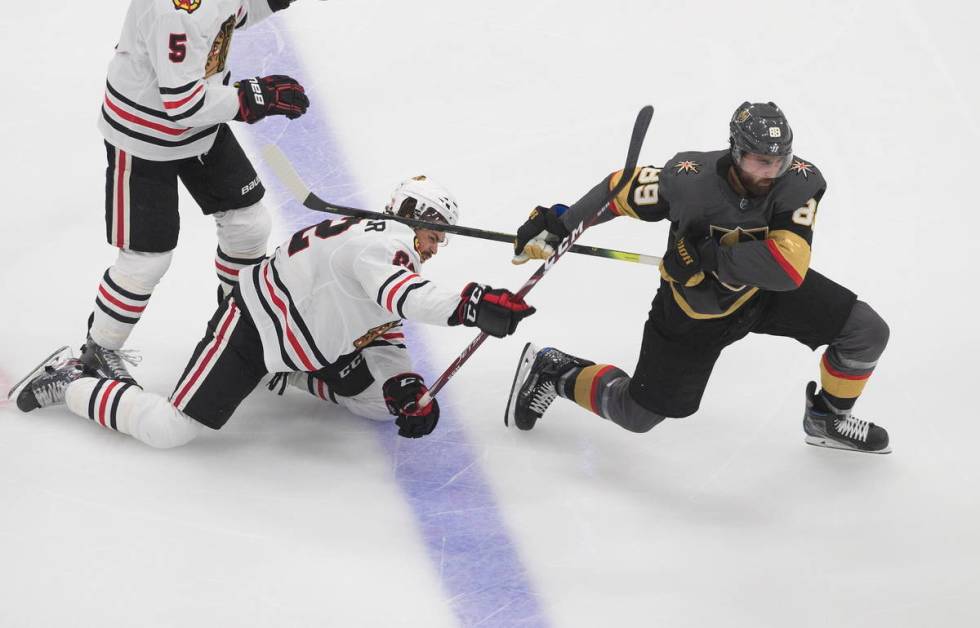 Vegas Golden Knights' Alex Tuch (89) and Chicago Blackhawks' Ryan Carpenter (22) battle for the ...