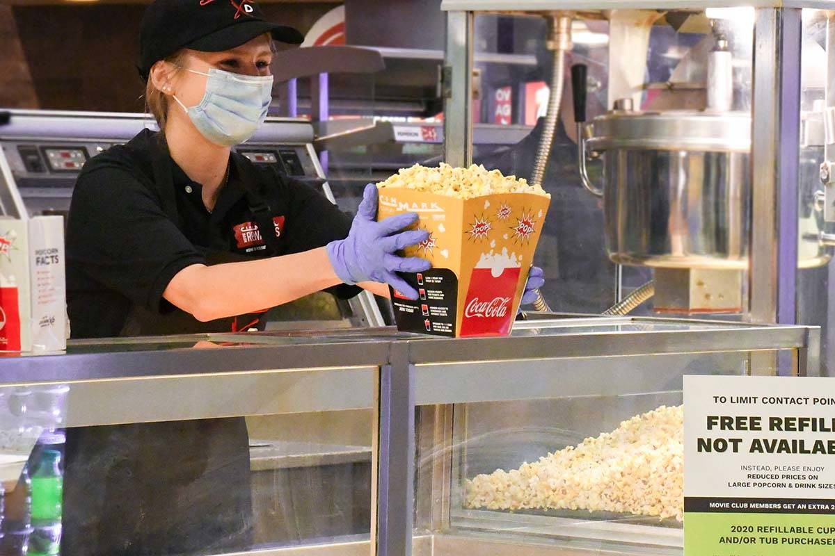A Cinemark employee prepares popcorn. Five Century-branded movie theaters operated by Cinemark ...