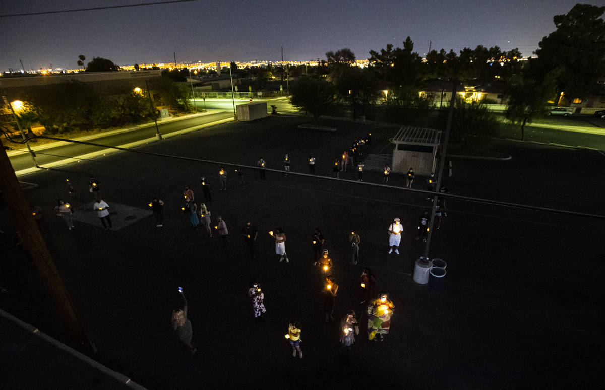 People gather in the shape of the trans symbol during a candlelight vigil, in remembrance of th ...