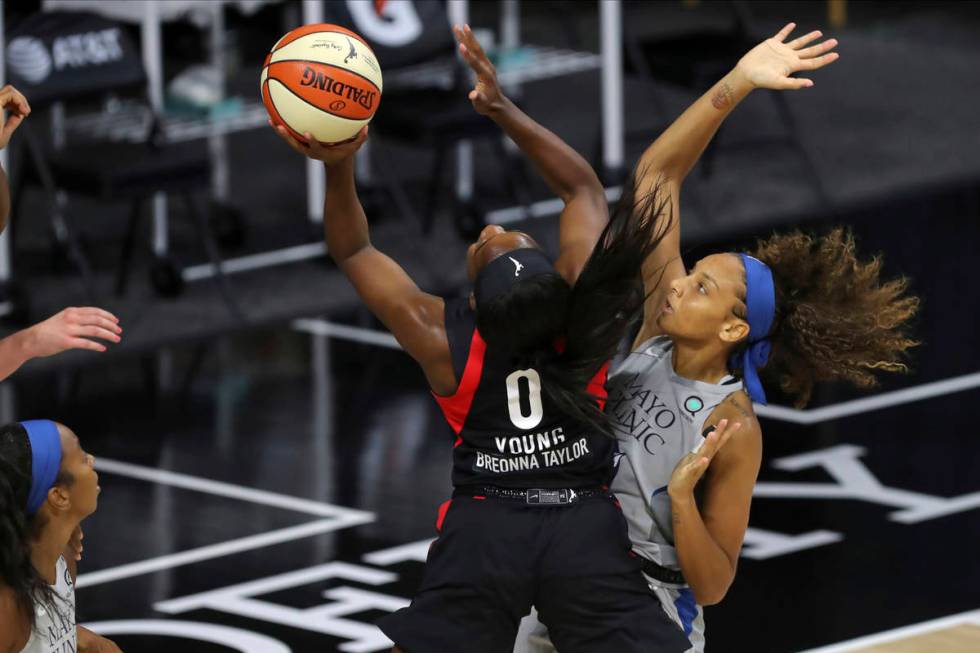 Las Vegas Aces' Jackie Young (0) shoots past Minnesota Lynx's Mikiah Herbert Harrigan during th ...