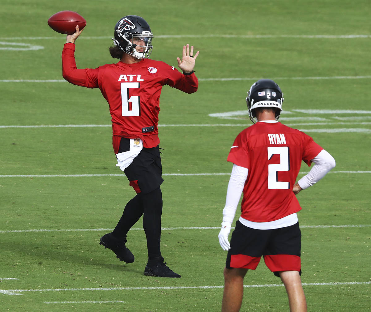 Atlanta Falcons backup quarterback Kurt Benkert completes a pass with Matt Ryan looking on duri ...