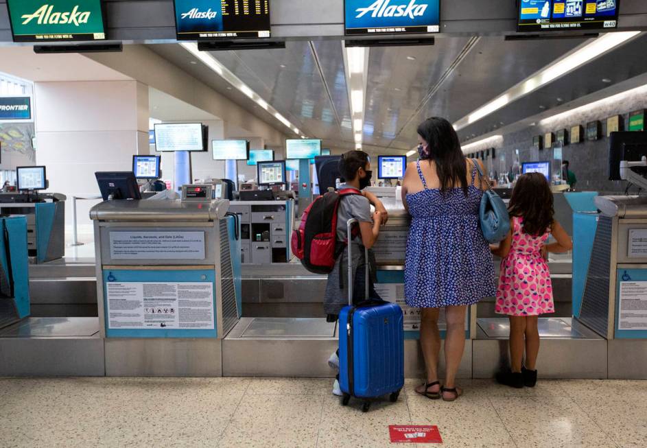 Cynthia Noriega and her two children, Evan York, 11, and Sarah York, 7, check in for Evan's fli ...