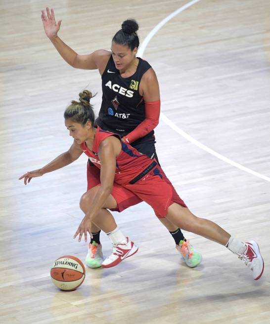 Washington Mystics guard Leilani Mitchell loses her balance while defended by Las Vegas Aces gu ...