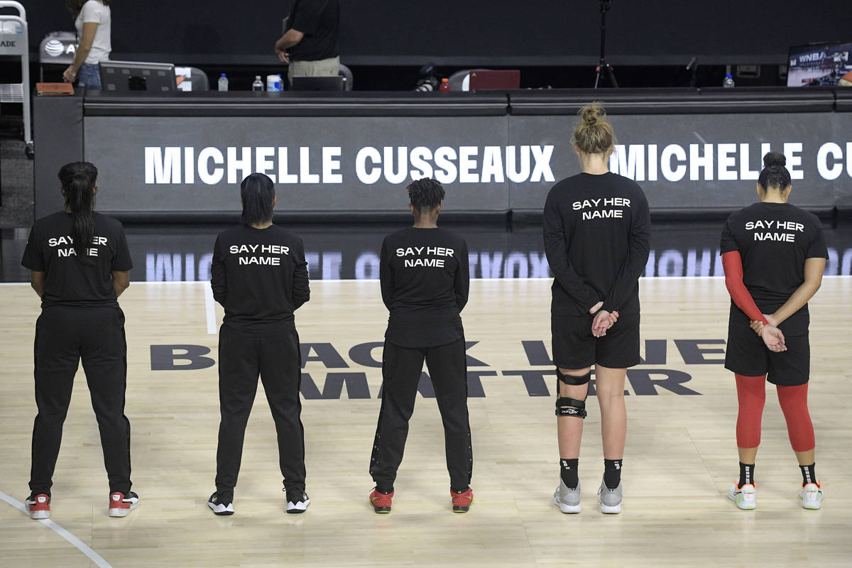 Members of the Las Vegas Aces honor Michelle Cusseaux with a moment of silence before a WNBA ba ...