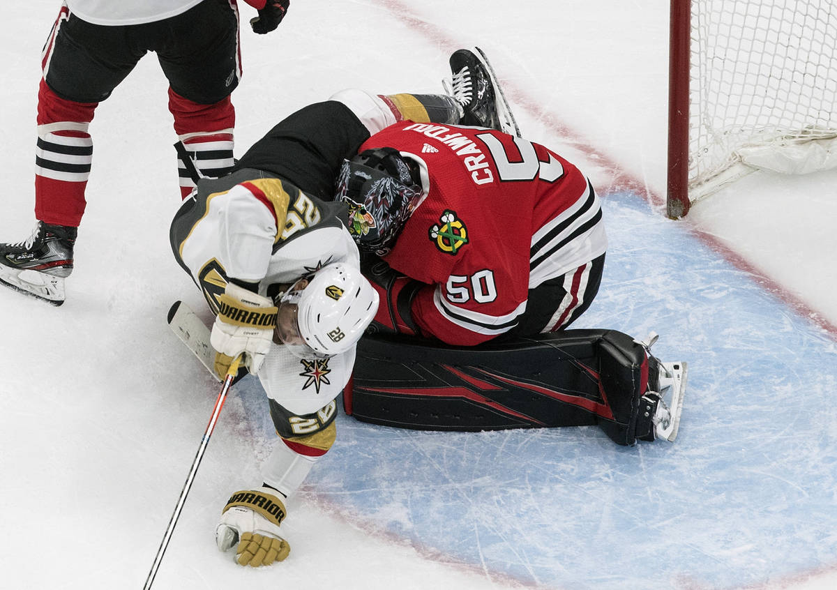 Vegas Golden Knights' William Carrier (28) crashes into Chicago Blackhawks goalie Corey Crawfor ...