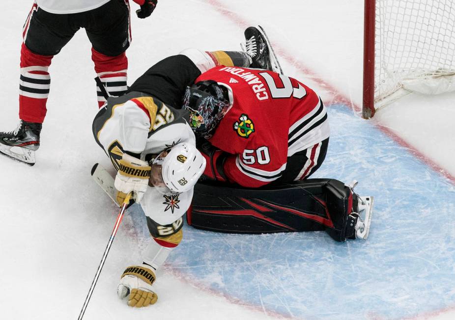 Vegas Golden Knights' William Carrier (28) crashes into Chicago Blackhawks goalie Corey Crawfor ...