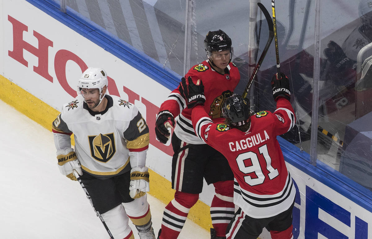 Vegas Golden Knights' Alec Martinez (23) skates past as Chicago Blackhawks' Olli Maatta (6) and ...