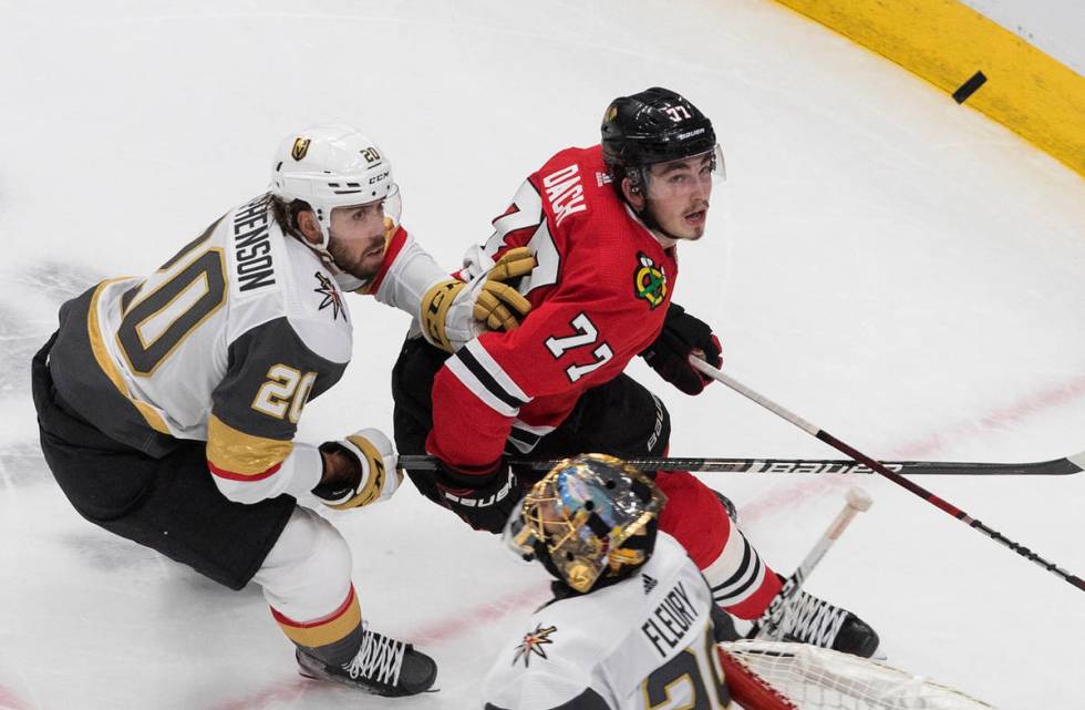 Vegas Golden Knights' Chandler Stephenson (20) and Chicago Blackhawks' Kirby Dach (77) chase th ...