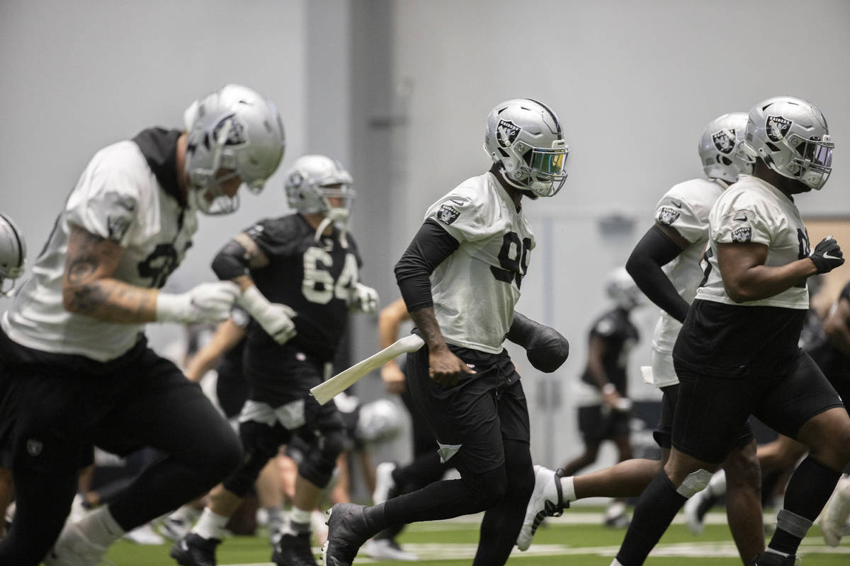 Raiders players warm up during NFL football training camp practice on Friday, Aug. 14, 2020, at ...