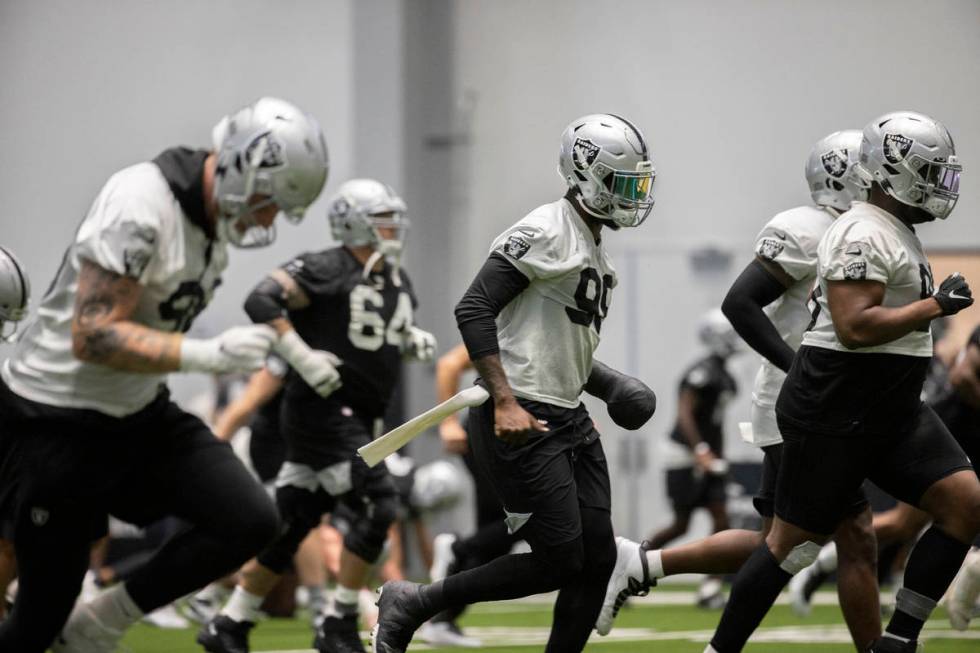 Raiders players warm up during NFL football training camp practice on Friday, Aug. 14, 2020, at ...