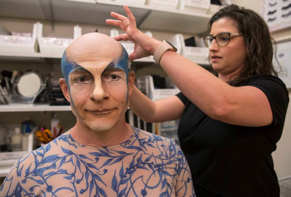 Performer and coach Didier Antoine, left, gets his makeup applied to play the role of Morpheus ...